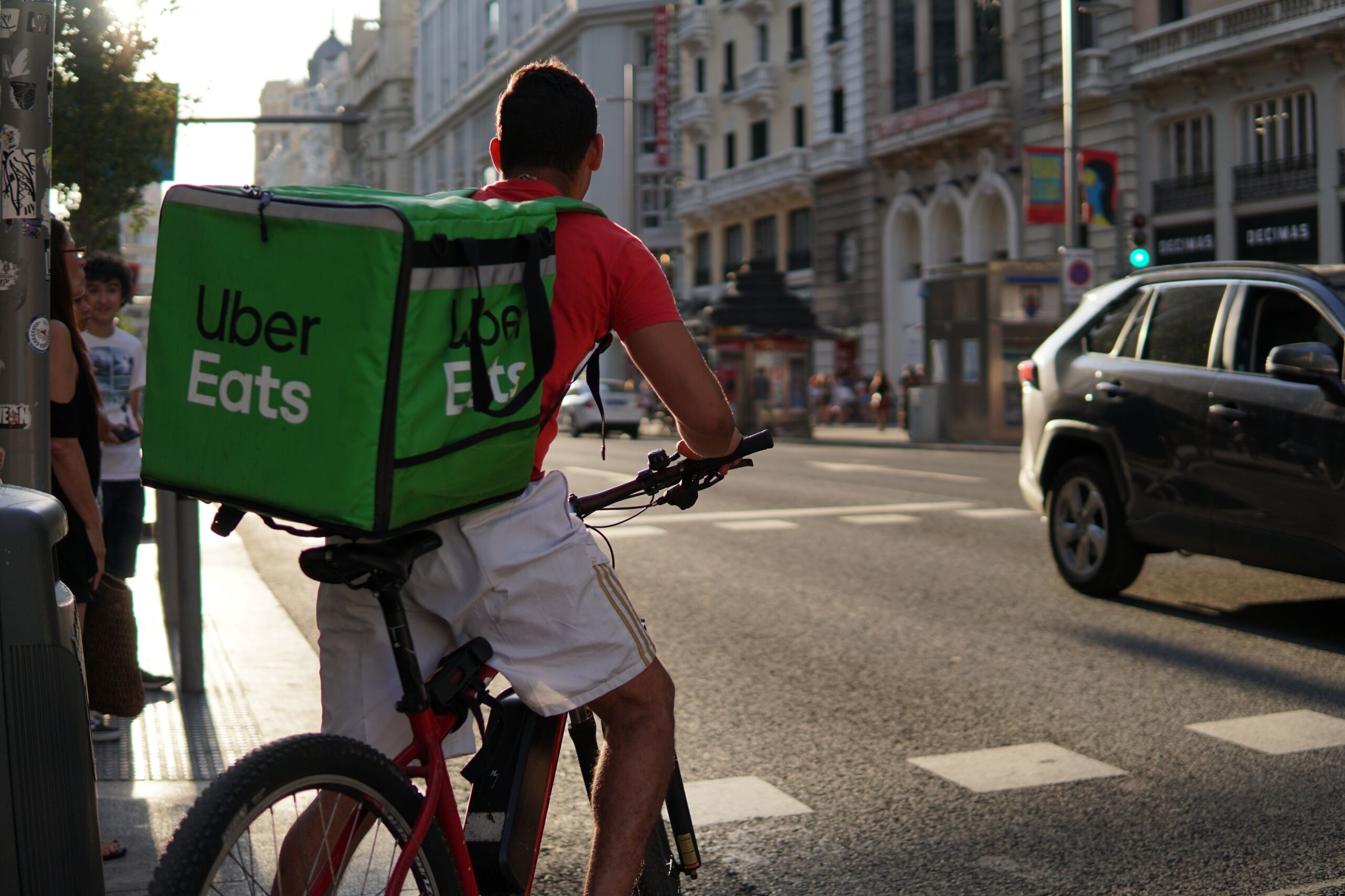 Uber Eats bike delivery driver waiting to cross the road